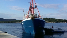 Fishing boat pulling in to dock with some help